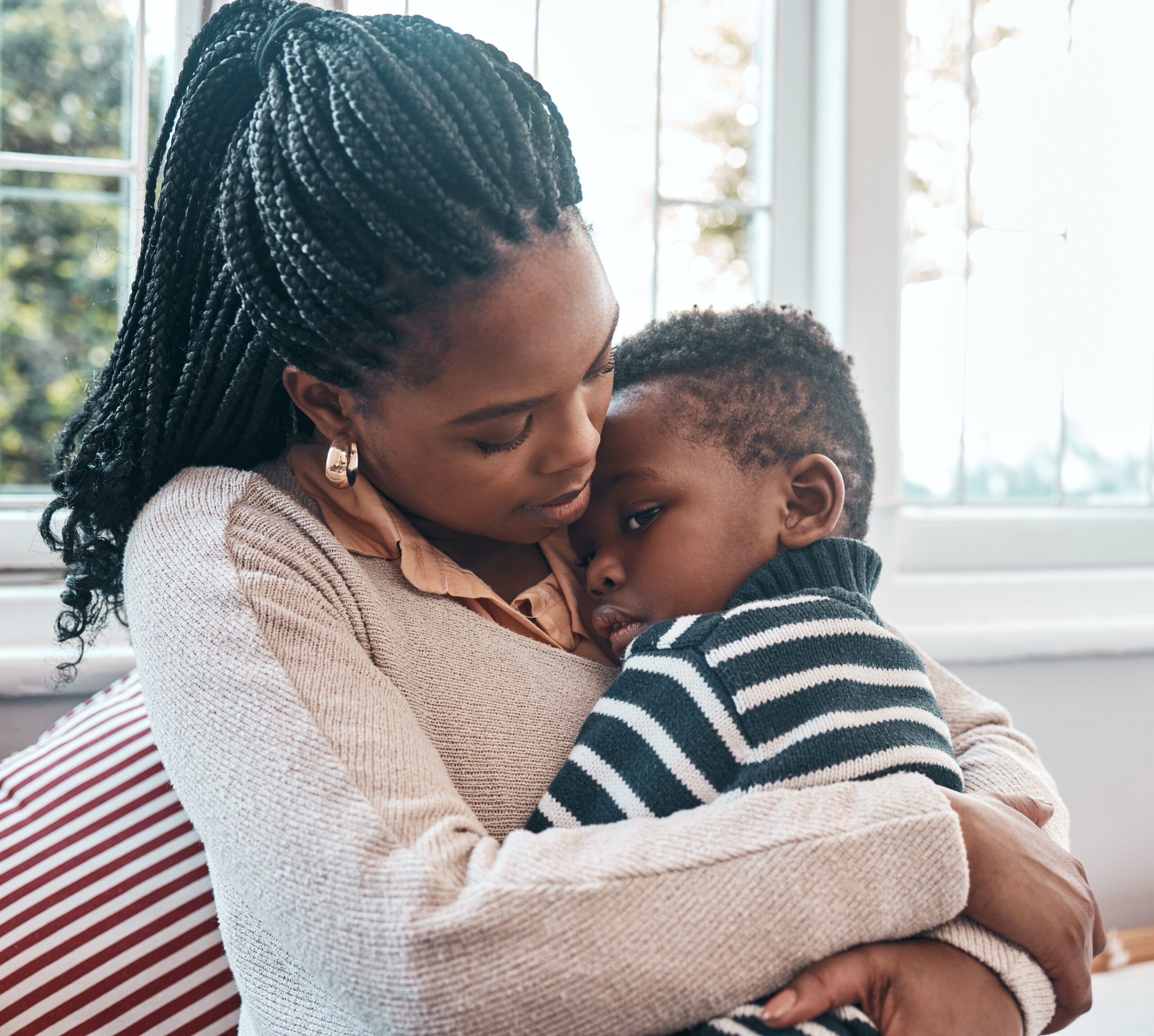 I hope you feel better soon. Shot of a woman comforting her young son at home