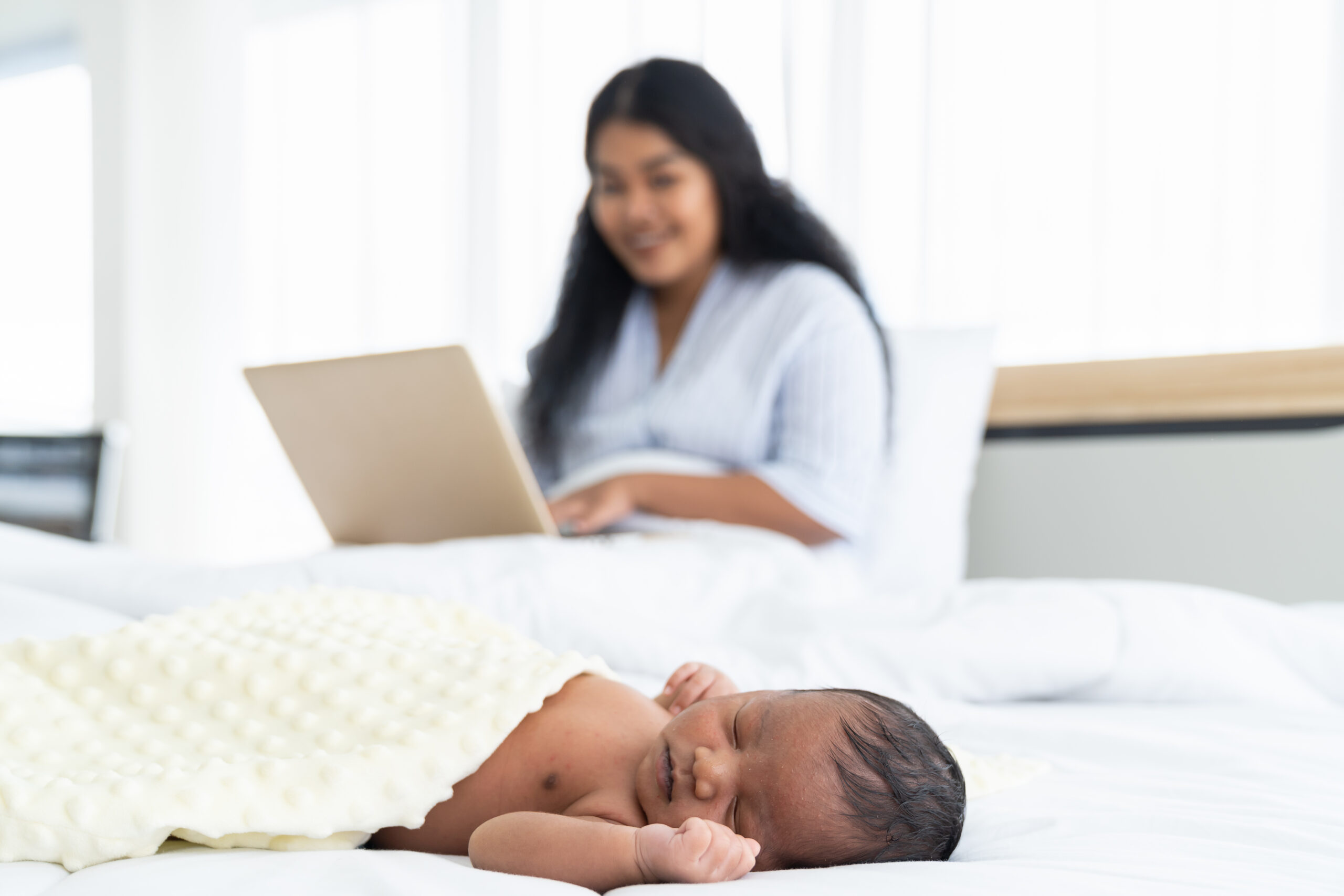 mother-works-while-baby-sleeps-on-bed-2026-03-26-09-47-42-utc