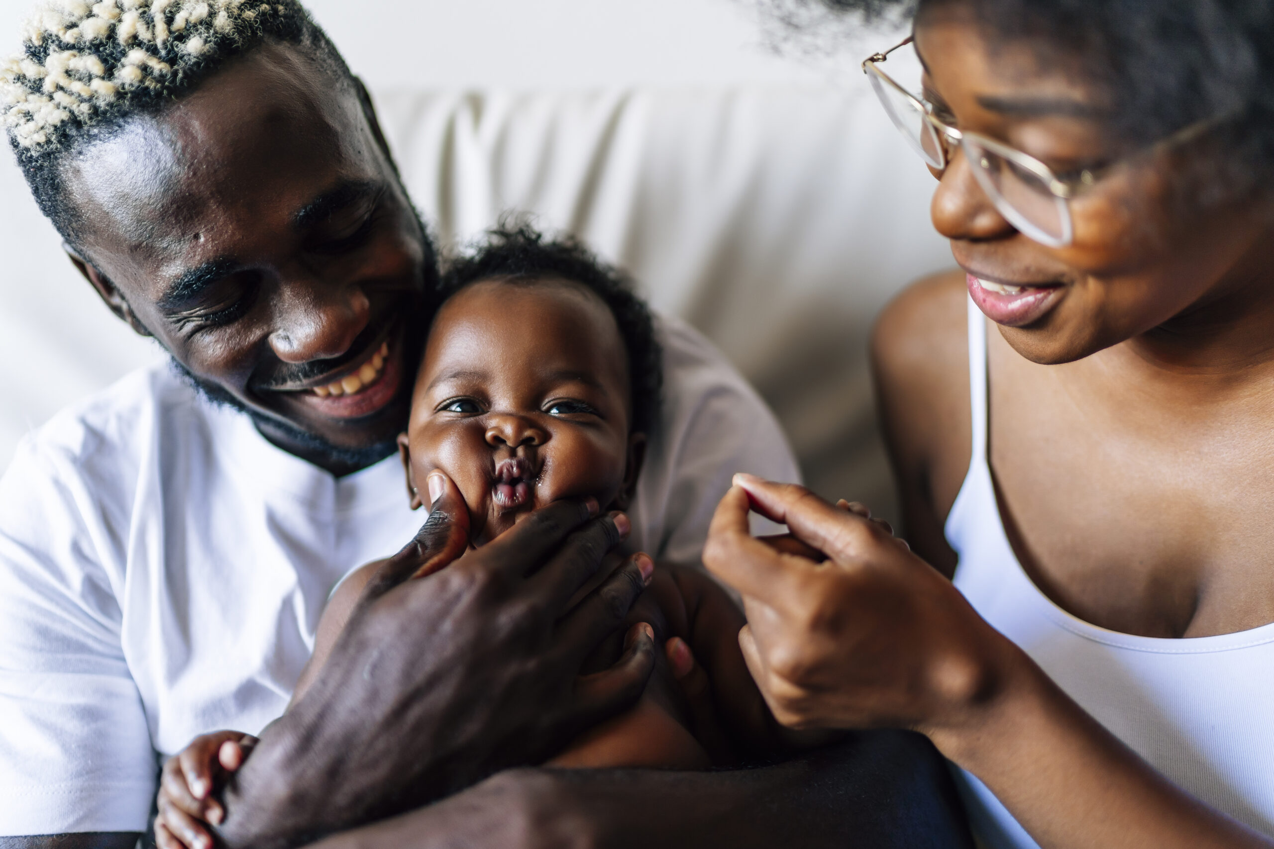 A cheerful family of African-Americans with a mother, father and baby having fun together