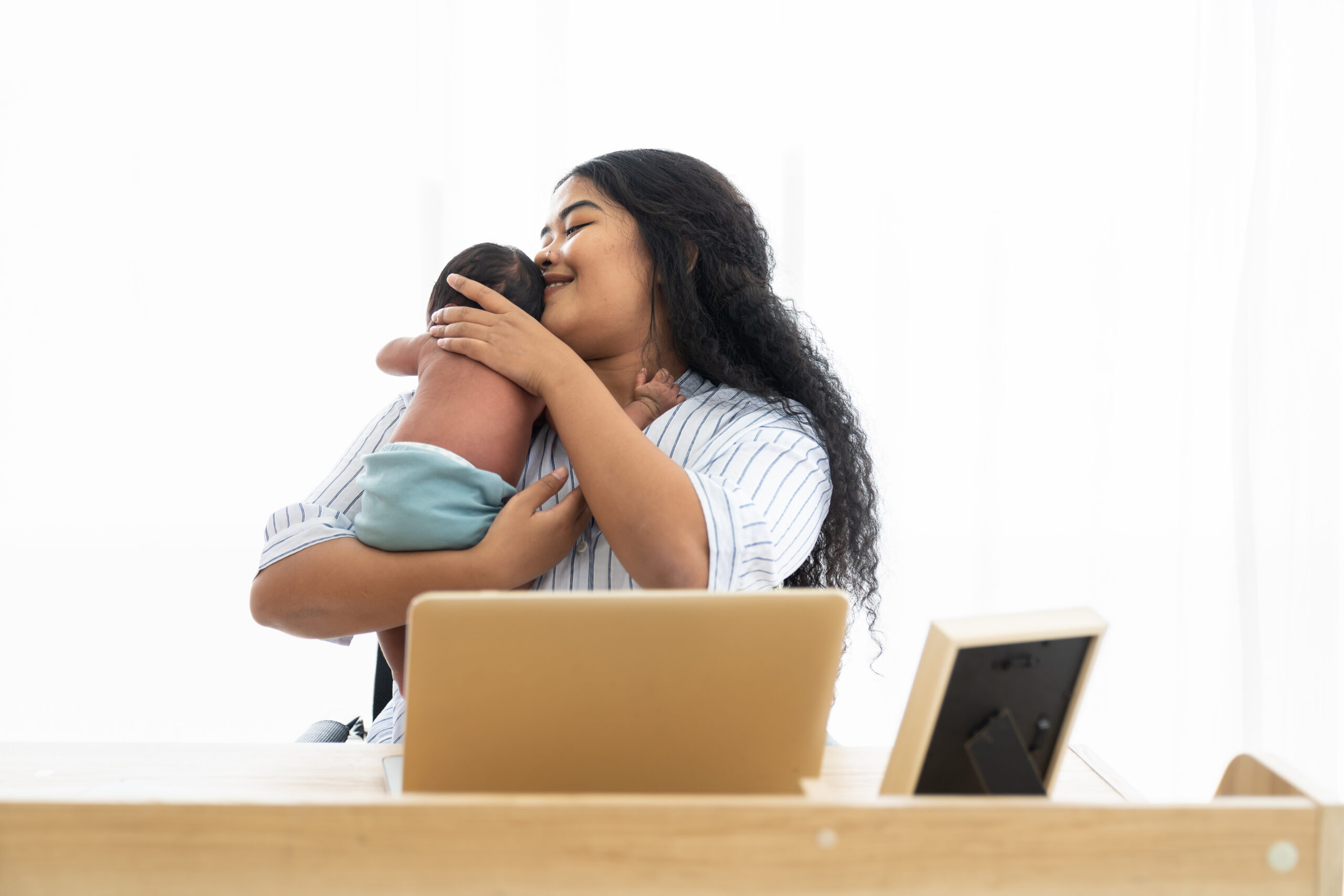 happy-mother-holds-newborn-at-desk-at-home-2026-03-26-08-51-09-utc